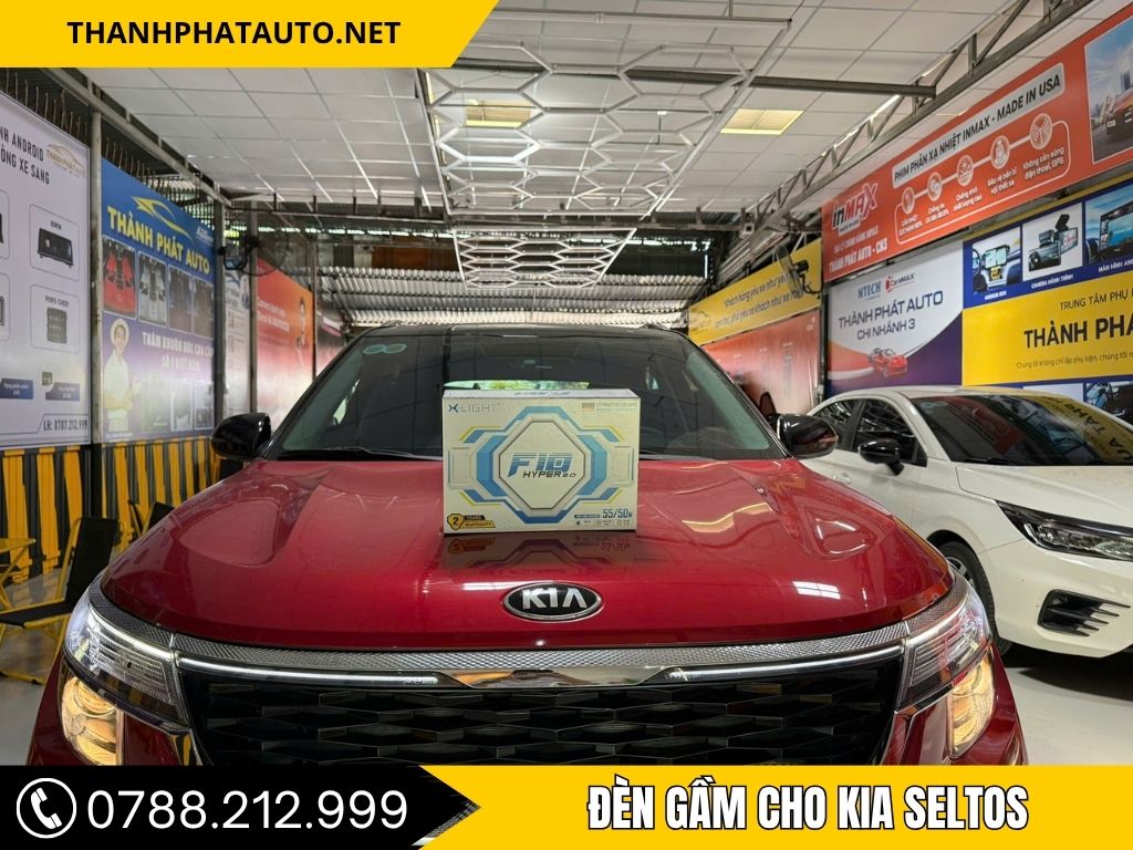 Chiếc Kia Seltos màu đỏ đậu trong gara Thành Phát Auto, trên nắp capo có đặt hộp đèn gầm X-Light F10 Hyper 2.0.